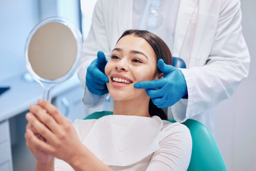 Dentist, mirror and woman check smile after teeth cleaning, braces and dental consultation. Healthcare, dentistry and happy female patient with orthodontist for oral hygiene, wellness and cleaning